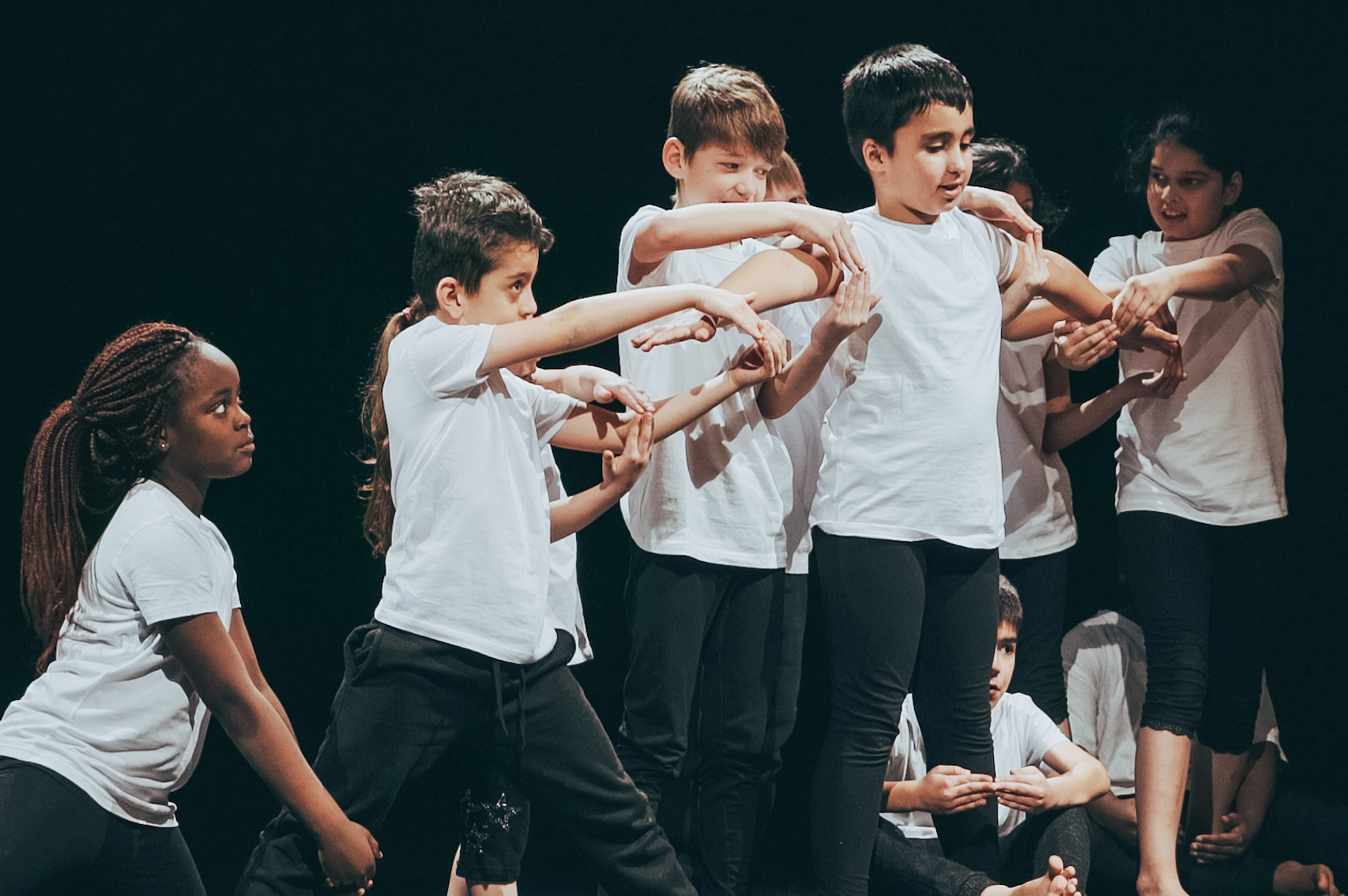Grundschüler:innen tanzen zusammen auf einer Bühne